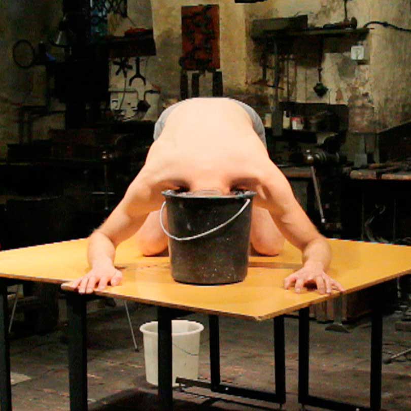 in the performance Matthias Mollner puts his head in a water filled bucket